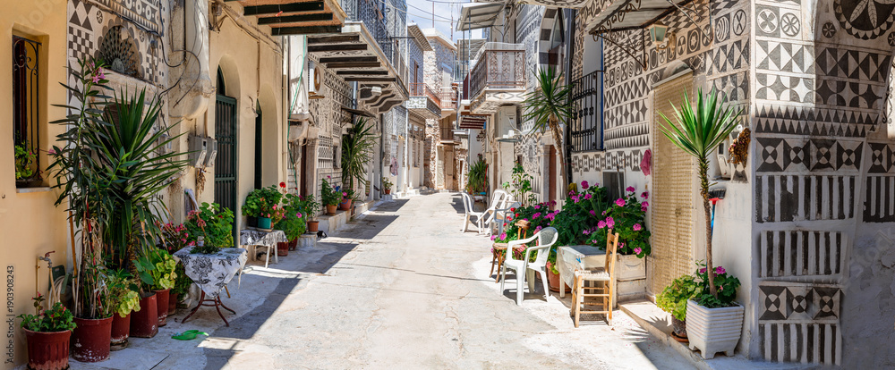 Obraz premium Panoramic View of Pyrgi Village with Traditional Geometric Xysta Wall Paintings and Sunny Empty Street Chios Island Authentic Mediterranean Aesthetic Mastic Villages Greece. high resolution print