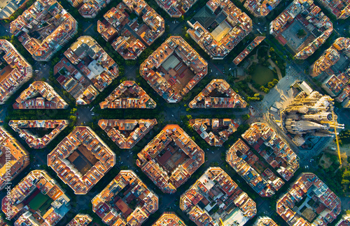 Photography Wide aerial sunrise view of Barcelona with the Sagrada Familia visible among the Eixample grid