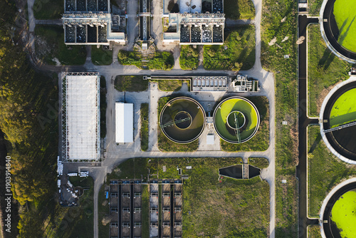 Aerial view of a wastewater treatment plant with round tanks and rectangular buildings, a symphony of industrial architecture, Rome, Lazio, Italy.