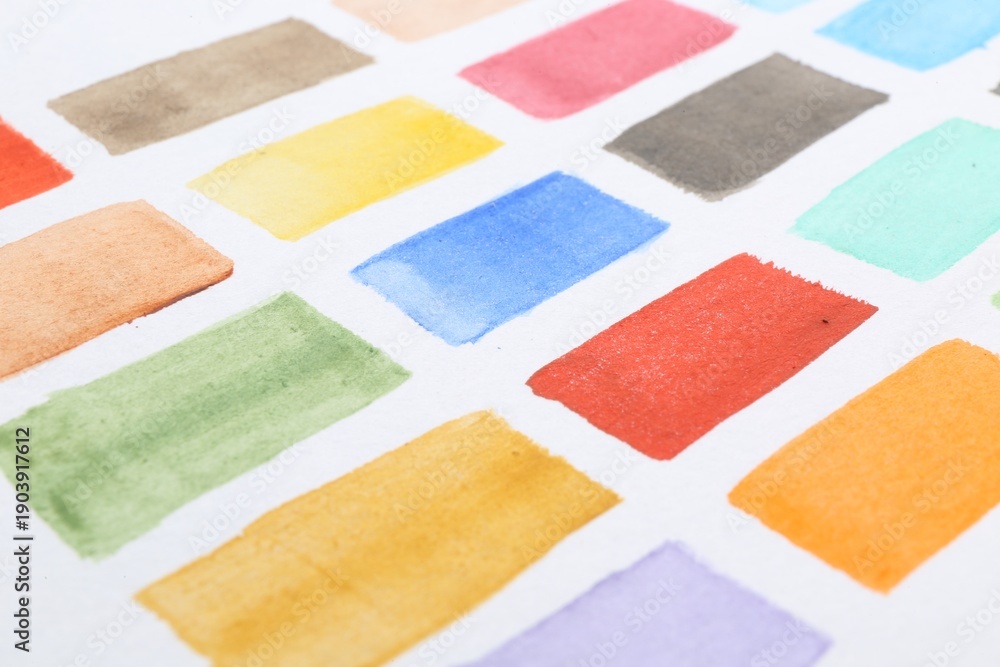 Fototapeta premium Painted watercolor strokes on white sheet of paper, closeup