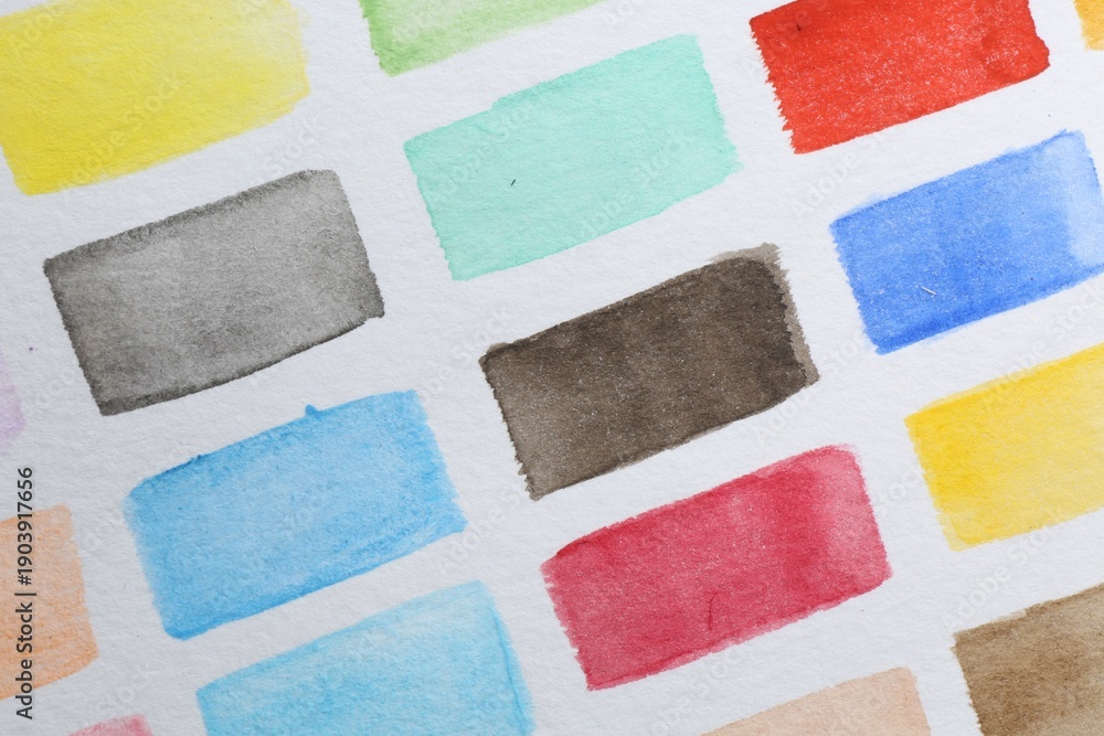 Fototapeta premium Painted watercolor strokes on white sheet of paper, top view