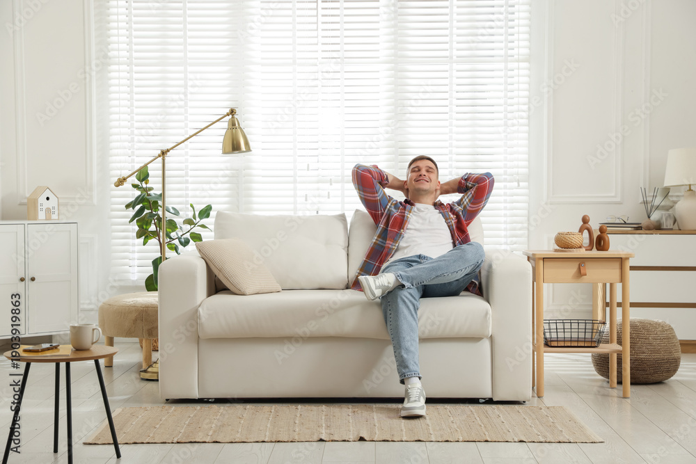 Obraz premium Young man relaxing on sofa at home