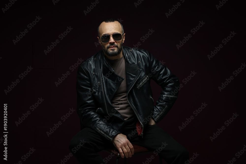 Obraz premium Fashion model. Handsome man in sunglasses on black background