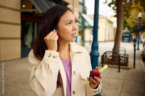 Woman utilizes wireless earbuds