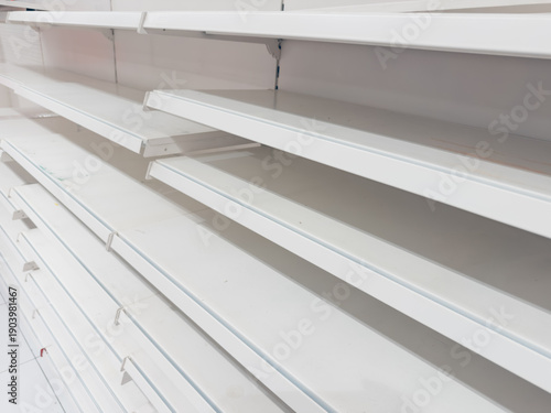 Empty store shelves concept showing shortage, supply chain disruption, inflation, economic crisis and panic buying impact in retail industry background