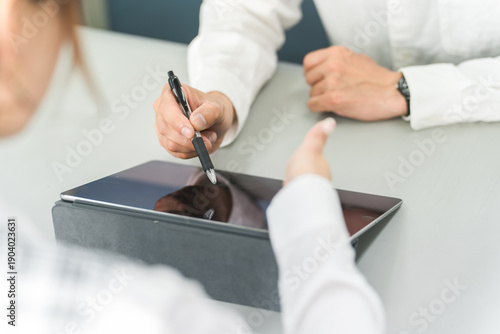 Bilde på lerret Staff using a tablet to guide customers and customers operating and signing