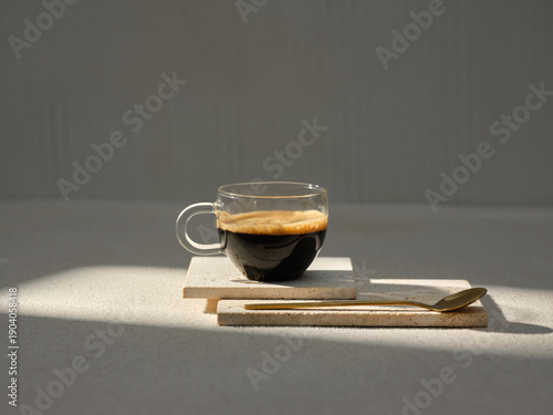 A steaming cup of espresso is presented on travertine tiles