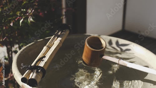 日本の伝統的な手水鉢と竹の柄杓から流れる水
