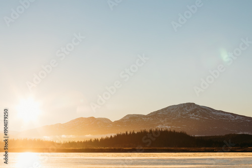 Winter sun over frozen lake in the Swedish mountains