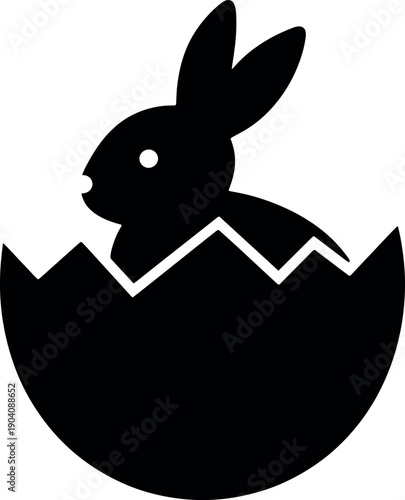 Simple black silhouette bunny emerging from cracked eggshell on white background