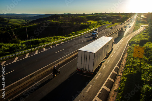 Wallpaper Mural Marilia, SP, Brazil, November 19, 2025. Highway SP-294 in Marilia, at sunset. Intense traffic of cars and trucks flows through the green landscape, illuminated by the golden hour light. Torontodigital.ca