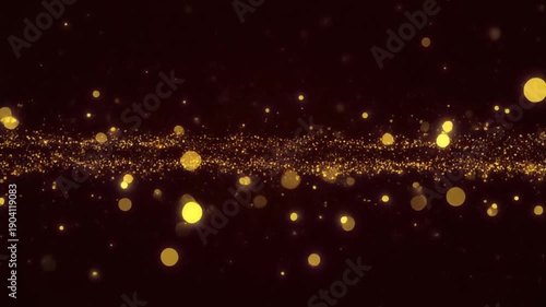 Glittering gold sparkles falling against dark background with bokeh effect for overlay or overlay