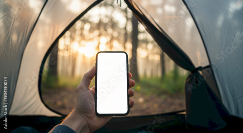 Hand Holding Smartphone Inside Tent With Forest Sunrise View.