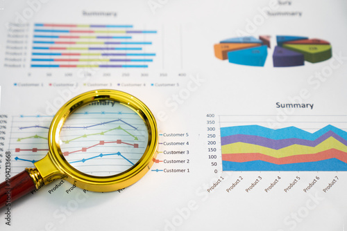 Magnifying glass on graph paper chart;

