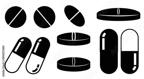 Various black and white medical capsules and pills arranged neatly on a plain background from a straightforward viewpoint