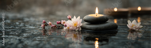 Spa-inspired background featuring smooth black stones, delicate white and pink flowers, and a softly glowing candle flame on water surface for relaxation and tranquility
