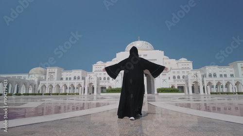  Qasr Al-Watan Presidential Palace in Abu Dhabi .A girl in a black abaya walks along the front of the palace square.