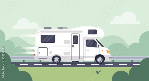 A white recreational vehicle drives along a road with green scenery