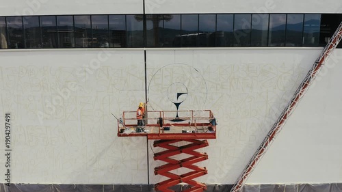 Mural artists painting a building facade