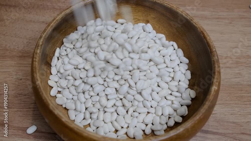 Dried beans poured into wooden bowl
