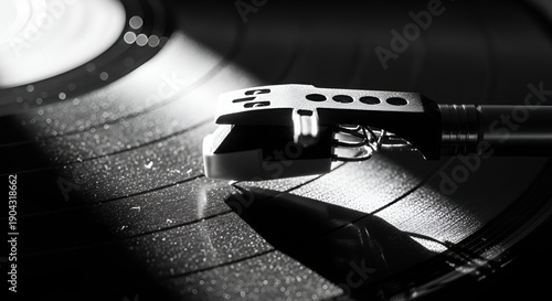 Vintage record player tonearm on a vinyl record in black and white.