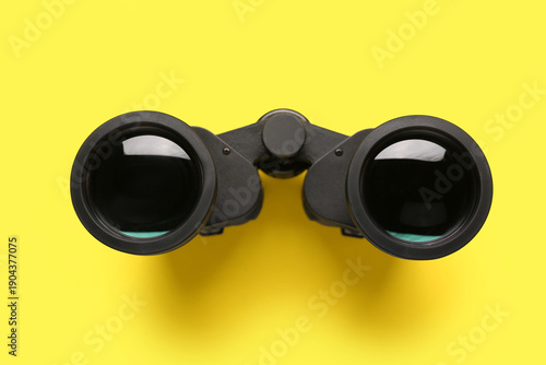Black binoculars on yellow ...