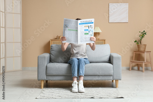 Young woman reading newspap...