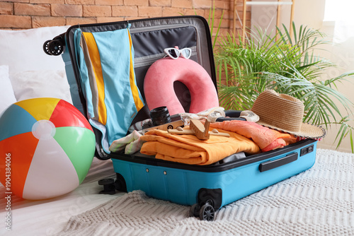 Open suitcase with beach ac...