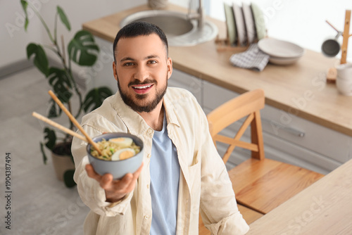 Young man with tasty ramen ...