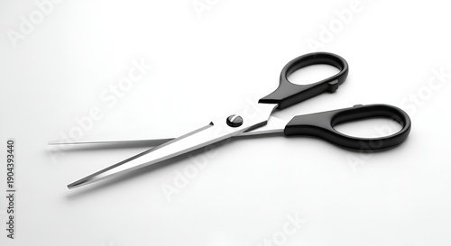 A pair of sharp scissors with black handles lies open on a white surface, viewed from directly above.
