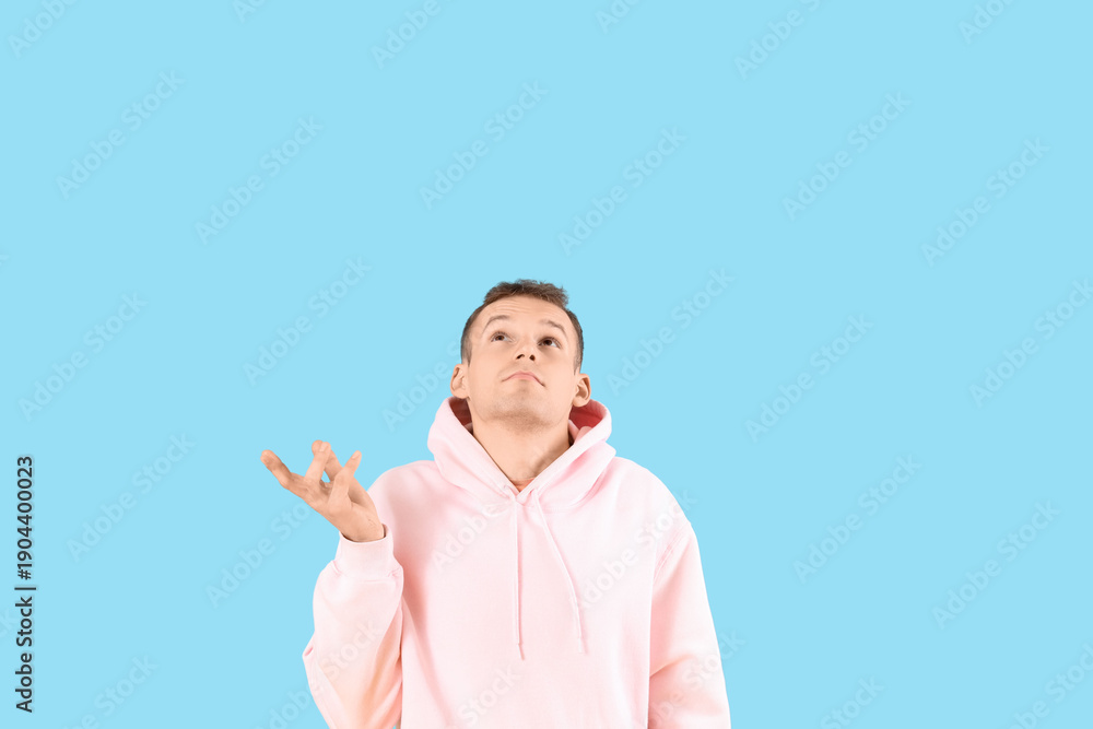 Fototapeta premium Wondering young man on blue background