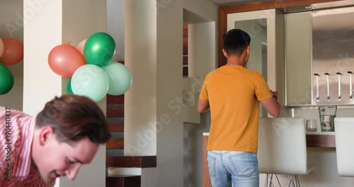 Dancing joyfully at home, gay couple celebrating festive occasion together