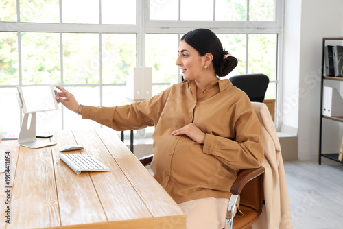 Pregnant businesswoman work...