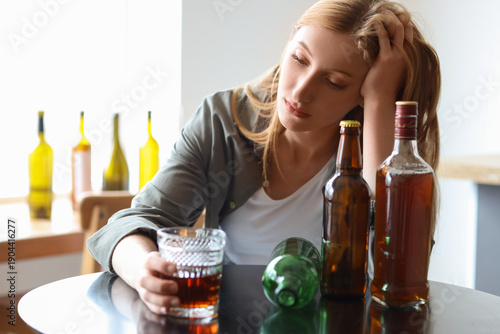 Foto Young woman drinking whiskey at home. Concept of alcoholism