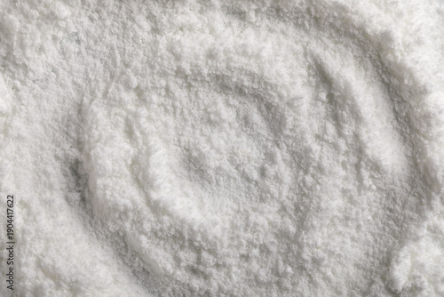 Foto Macro close-up photo of vitamin E powder forming a circular swirl pattern on a smooth creamy white surface