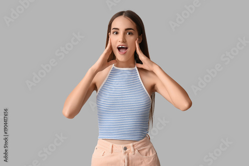 Surprised young woman with diastema on light background