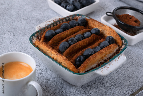 Tablou pe pânză Trendy Japanese yogurt cheesecake with cookies biscuit and blueberries on a gray background