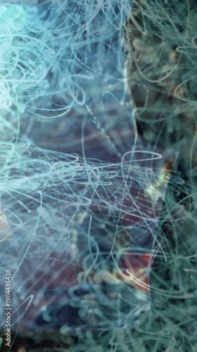 Vertical video: Curly-haired fan reaching stage, wristband sparking blue light trails during music