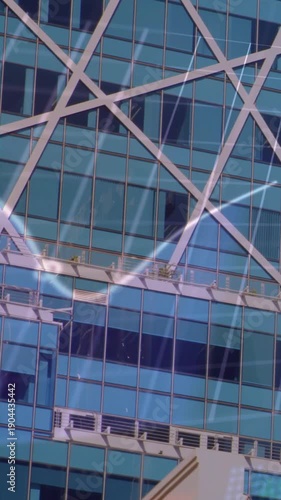 Vertical video: Faint streak appearing, light trail sweeping down high-rise glass, showing lattice