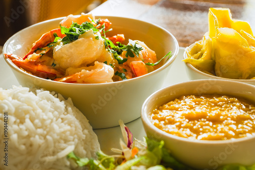 Obraz na plátně Traditional Creole meal from Seychelles featuring succulent grilled prawns in a rich garlic butter sauce, accompanied by flavorful lentils, a refreshing mango salad, and aromatic basmati rice