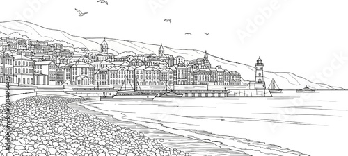 A pebble beach slopes towards a coastal town with a lighthouse and boats