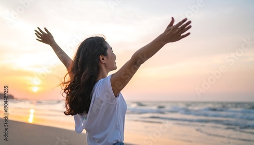 Wallpaper Mural Woman with arms raised in the air on a beach at sunset, feeling free and happy. Torontodigital.ca