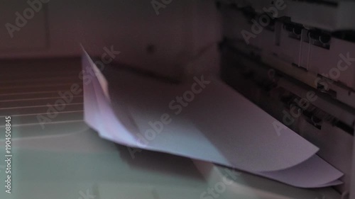 Closeup View of Paper Being Ejected from a Printer with a Soft Lighting Effect on the Device Surface