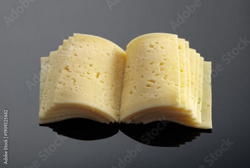Obraz na plátně Cheese on a black reflective background.