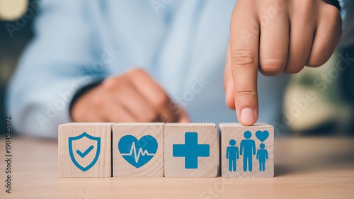 Wallpaper Mural Finger pointing at wooden blocks with icons for health, family, and protection insurance Torontodigital.ca
