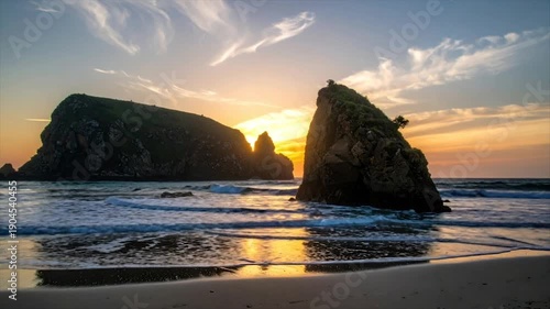 Wallpaper Mural Golden sunset casts a warm glow over a beach scene with rocky formations and gentle waves Torontodigital.ca