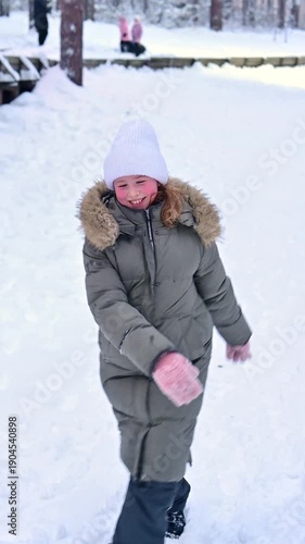Beneath a blanket of fresh snow, a cheerful girl walks in her warm coat, pulling her vibrant snow tube. Excitement fills the air as she prepares for a day of winter fun with friends.