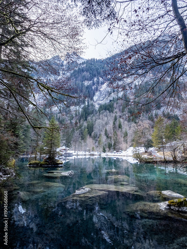 Photography Turquoise alpine lake with mirror-like reflections and snow-dusted mountains - K