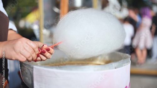 Canvas Print Vendor making fresh cotton candy at a street food market stand