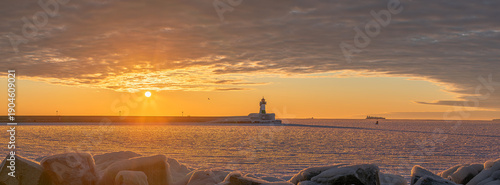 Panorama-Sonnenaufgang über zugefrorener Ostsee mit Leuchtturm Sassnitz und Schiffssilhouetten, Insel Rügen, Mecklenburg-Vorpommern, Deutschland